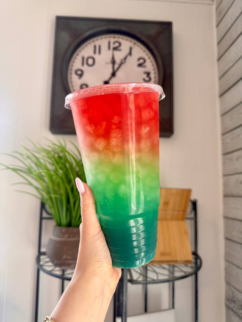 A finished, layered Mega Tea drink in a tall clear cup